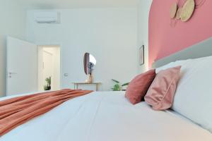 a bedroom with a white bed with pink walls at Residenza Bacco - Porta Nuova in Verona
