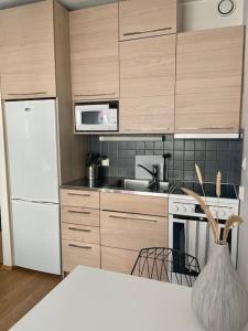 una cucina con frigorifero bianco e piano cottura di Lovely studio in the famous Design District area. a Helsinki
