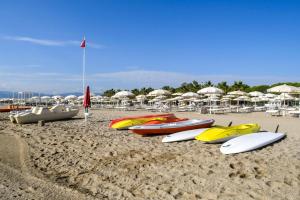 un grupo de tablas de surf y sombrillas en una playa en Salice Resort, en Marina di Schiavonea