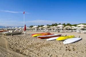 un grupo de tablas de surf y sombrillas en una playa en Salice Resort en Marina di Schiavonea