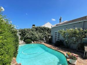 a swimming pool in the yard of a house at Lemon Tree Cottage in Edgemead
