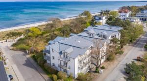 an aerial view of a white house with blue roofs at Ostsee Panoramaloft in Juliusruh