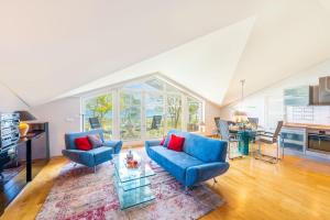 a living room with two blue couches and a table at Ostsee Panoramaloft in Juliusruh