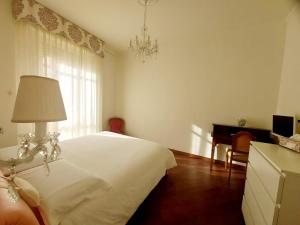 1 dormitorio con 1 cama blanca con lámpara y escritorio en Appartamento 3 Cuori en Terni
