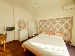 Un dormitorio con una gran cama blanca y una lámpara de araña. en Appartamento 3 Cuori en Terni