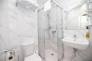 La salle de bains est pourvue d'une douche, de toilettes et d'un lavabo. dans l'établissement Pytloun Old Armoury Hotel Prague, Stará Zbrojnice, à Prague
