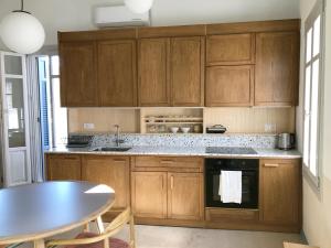 a kitchen with wooden cabinets and a table and a table at Giasemi house with sea view in Panormos Skopelos