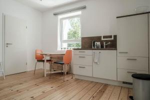 uma cozinha com armários brancos, uma mesa e uma janela em Kinderklinik, 600m zum Bahnhof 2B em Siegen