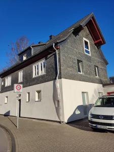 una casa grande con un coche aparcado delante de ella en Kinderklinik, 600m zum Bahnhof 2B, en Siegen
