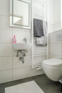 a white bathroom with a sink and a toilet at Kinderklinik, 600m zum Bahnhof 2B in Siegen
