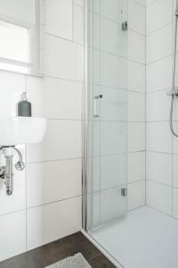 a white bathroom with a shower and a sink at Kinderklinik, 600m zum Bahnhof 2B in Siegen
