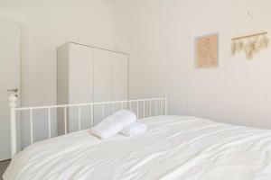 ein weißes Schlafzimmer mit zwei Kissen auf dem Bett in der Unterkunft סוויטת מול הבניאס in Kibbutz Snir