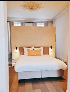 a bedroom with a large white bed with two lamps at Villa Ostinato in Ostend