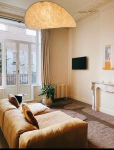 een woonkamer met een bank en een tv bij Villa Ostinato in Oostende