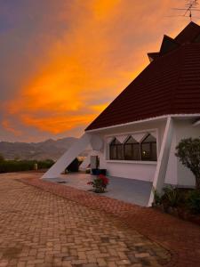 a house with a sunset in the background at Peace Farm in Hatta