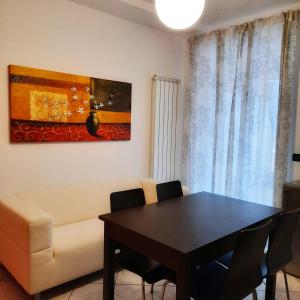 ein Wohnzimmer mit einem Tisch und einem Sofa in der Unterkunft Appartamento Pizzo di Parlasco - Your Mountain Holiday in Taceno