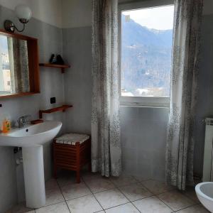 a bathroom with a sink and a window at Appartamento Pizzo di Parlasco - Your Mountain Holiday in Taceno