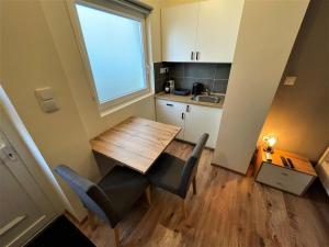 une petite cuisine avec une table et des chaises ainsi qu'une fenêtre dans l'établissement Hanna Apartman, à Debrecen