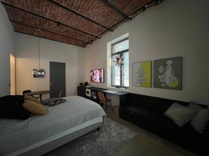 a bedroom with a bed and a desk and a window at Loft Suite in Lappeenranta