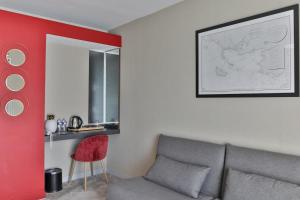聖菲利貝爾的住宿－鵝卵石酒店和Spa，带沙发和红色墙壁的客厅