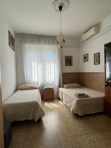 een slaapkamer met 2 bedden en een raam bij Ardenza Liberty in Livorno