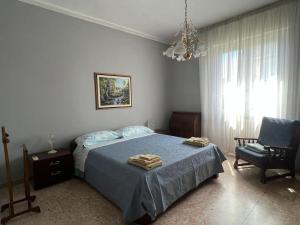 een slaapkamer met een bed, een stoel en een kroonluchter bij Ardenza Liberty in Livorno