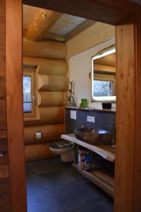 a bathroom with a sink and a wooden wall at Chalet-Enzian-Bayerwald in Arnbruck