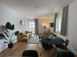 a living room with a couch and a table and chairs at Gmund Seeliebe Premiumsuite in Gmund am Tegernsee