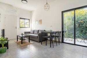 ein Wohnzimmer mit einem Sofa und einem Tisch in der Unterkunft סוויטת מול הבניאס in Kibbutz Snir