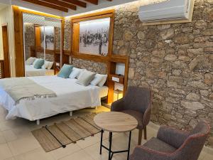 Hotel Rural Rosario Martin في بويرتو ديل روزاريو: غرفة نوم بسرير وطاولة وكراسي