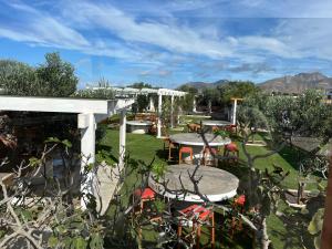 un patio con mesas y sillas en un jardín en Hotel Rural Rosario Martin en Puerto del Rosario