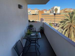 - un balcon avec une table et des chaises dans un bâtiment dans l'établissement Apartamento Ravel Playa Málaga, à Malaga