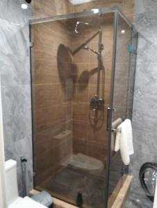 a shower with a glass door in a bathroom at 1-ком VIP квартира in Kostanay