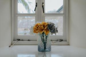 un vaso di fiori seduto su un tavolo di fronte a una finestra di Sheviock Barton Bed & Breakfast a Sheviock