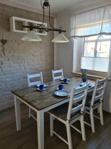 mesa de comedor con sillas blancas y mesa de madera en Ferienwohnung Flair, en Dölzig