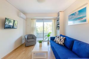 ein Wohnzimmer mit einem blauen Sofa und einem Stuhl in der Unterkunft Glyfada Center Sea View Apt in Athen
