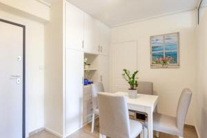 un comedor blanco con una mesa y sillas blancas en Glyfada Center Sea View Apt, en Atenas