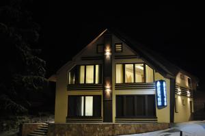 a house with a sign on the front of it at night at Garnet Star Apartments, Kopaonik, apartman broj 4 in Kopaonik