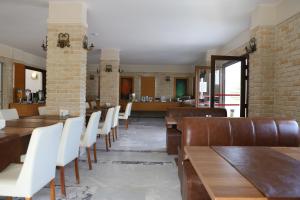 a dining room with wooden tables and white chairs at Hotel Binlik in Dalyan