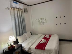 Schlafzimmer mit einem Bett mit einer roten und weißen Decke in der Unterkunft Jasmine Place House in Luang Prabang