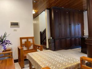 Zimmer mit einem Bett, einem Schrank und einem Tisch in der Unterkunft Jasmine Place House in Luang Prabang