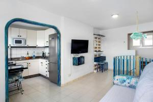 Las Sales Duplex في Moya: مطبخ وغرفة معيشة مع ثلاجة وطاولة