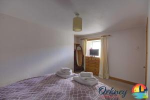 - une chambre avec un lit et des serviettes dans l'établissement Khyber Pass Cottage, Stromness - OR00332F, à Stromness