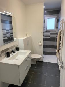 a bathroom with a white sink and a toilet at Repos paisible in Talmont