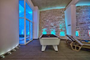 Habitación con mesa de billar y pared de ladrillo en Maltese Luxury Villas - Sunset Infinity Pools, Indoor Heated Pools and More!, en Mellieħa