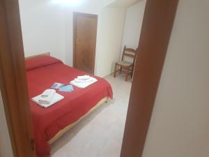 a bedroom with a red bed and a chair at Appartamenti Oleandri Baia Verde in Gallipoli