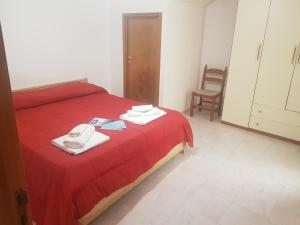 a bedroom with a red bed with towels on it at Appartamenti Oleandri Baia Verde in Gallipoli