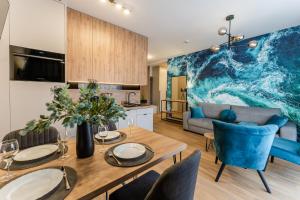 a kitchen and living room with a table and chairs at Sunset Resort III, Nadmorska 100A in Grzybowo