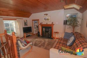 a living room with a couch and a fireplace at Khyber Pass Cottage, Stromness - OR00332F in Stromness