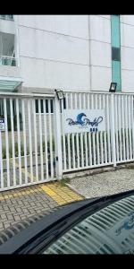 una valla blanca delante de un edificio con una señal en Reserva Pontal, en Río de Janeiro